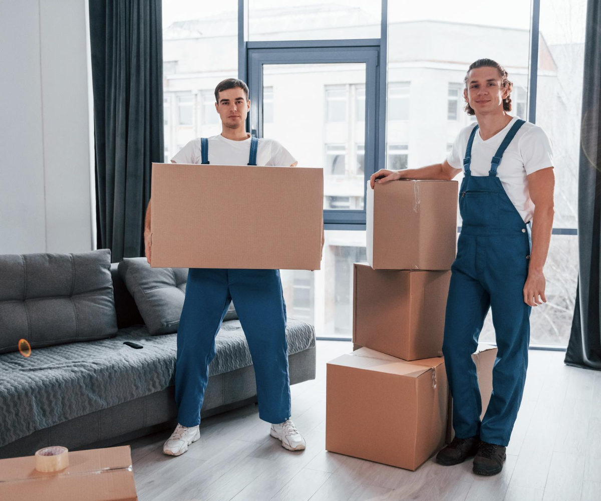 Residential movers holding packed boxes inside home – Moving Pro Dallas